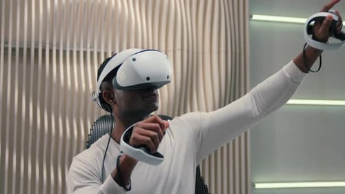 Man Uses VR Headset and Controllers Indoors