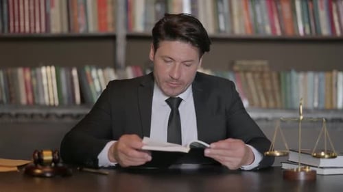 Male Lawyer Reading Law Book in Office