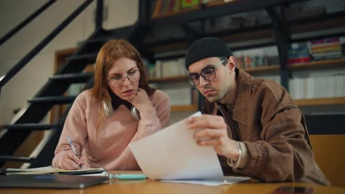 Students Study Together in a Library During Daytime Focusing on Their Assignments and Sharing Ideas