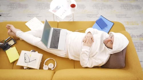 Adult Relaxing with Laptop on Couch at Home
