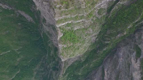 An incredibly beautiful view from above on a steep rock and a mountain abyss going down.