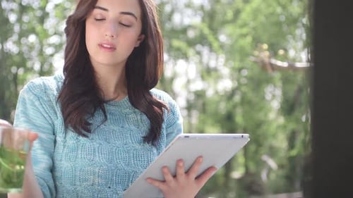 MS TU Woman drinking and using digital tablet / Breda, Noord-Brabant, Netherlands