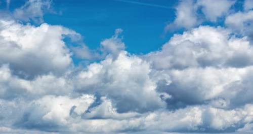 Billowing White Clouds Pass in a Blue Sky