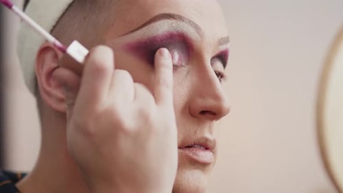 Person Applying Dark Eyeshadow with Brush Close Up