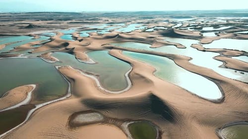 Aerial Shot of Oasis Amidst Desert Dunes