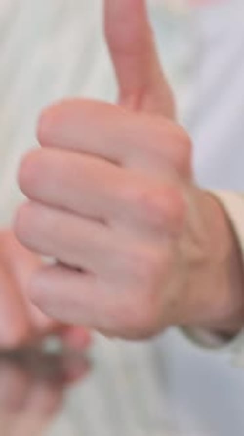 Close of Thumbs Up by Man in Office, vertical video