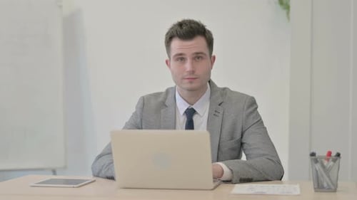 Young Adult Male Smiles in Office Setting