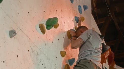 Man Rock Climbing on Indoor Colorful Climbing Wall