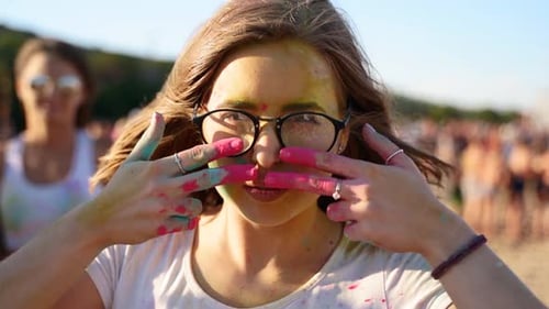 Pretty Woman in Glasses Painting Stripes on Her Cheeks with Fingers in Pink Colored Powder in Slow
