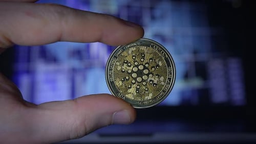 Gold Cardano Coin Held in Hand Close-Up
