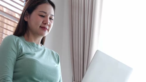 Woman Using Laptop Computer in Bright Home