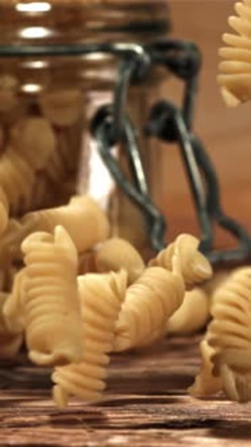 Fusili Pasta Falls on a Wooden Table Filmed on a Highspeed Camera at 1000 Fps