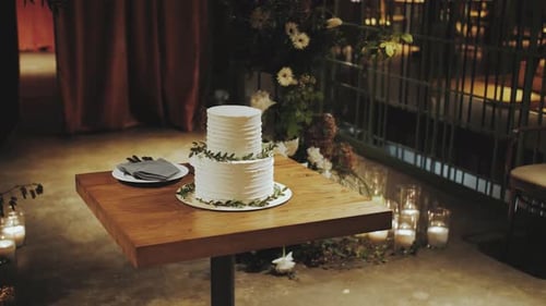 Beautiful Wedding Cake Decorated with a Sprig of Greenery on the Wooden Table in the Restaurant