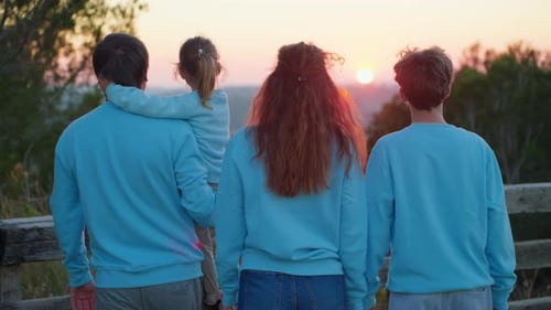 Happy Family Walking in Park on Grass at Sunset Childhood Concept and Childhood Young Mom Dad with a