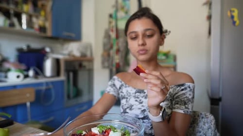 Woman Enjoys Healthy Salad in Bright Kitchen