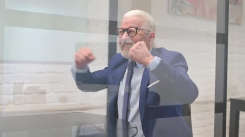 Senior Man Upset at Desk in Bright Office