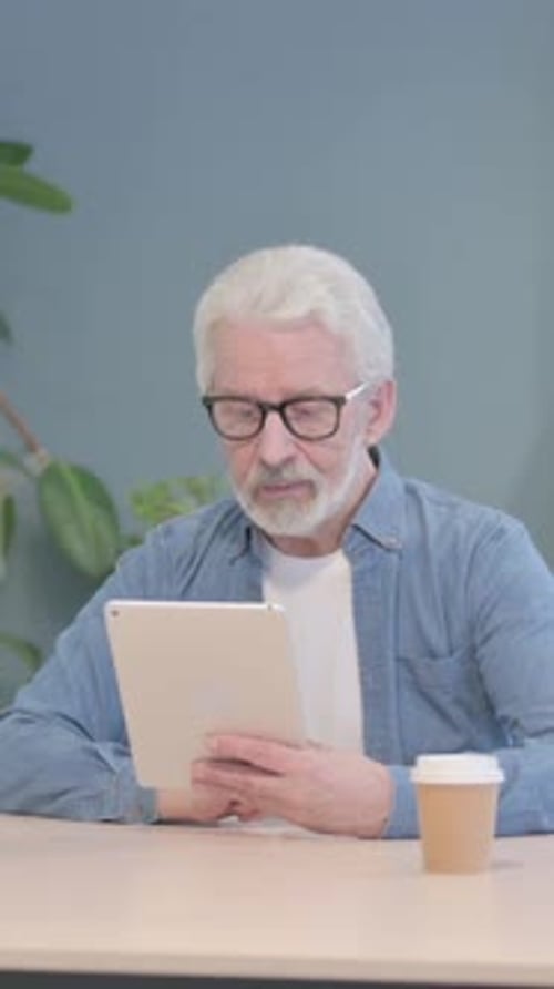 Senior Man Video Calling on Tablet Indoors