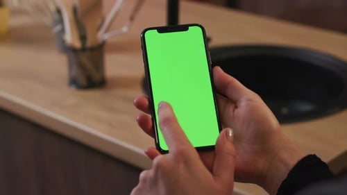 Tokio Japan April 7 2018 Woman Hand Hold Use Smartphone with Vertical Green Screen on Kitchen at