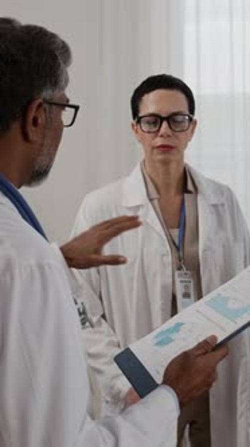 Medical Professionals Reviewing Charts in Hospital Room