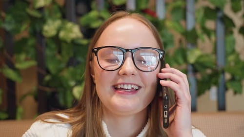 Close Up Woman Smiling on Phone During Breakfast in Cozy Cafe Setting