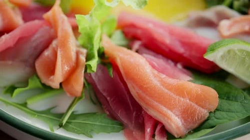 Close up of fresh raw fish slices with greens in a salad