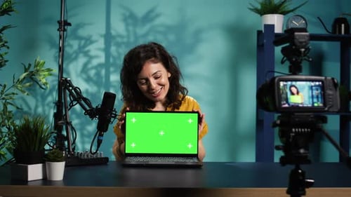 Woman Presenting Laptop with Green Screen in Studio