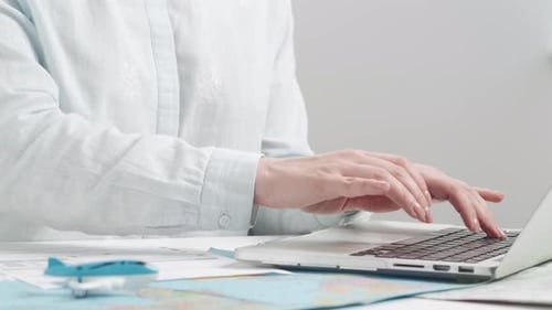 Travel Agent Typing on a Laptop Keyboard