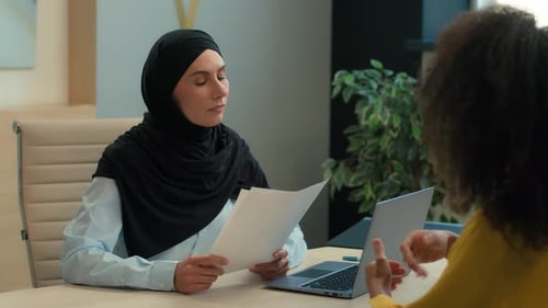 Two Women Discussing Business in Office Setting