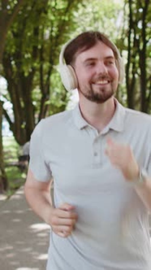 Athletic Fitness Sport Runner Man Training Marathon Run Listening Music in Headphones Workout Cardio