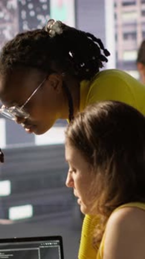 Colleagues Collaborate on Computer in Bright Urban Office