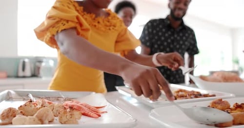 Woman serving roasted vegetables at a kitchen table