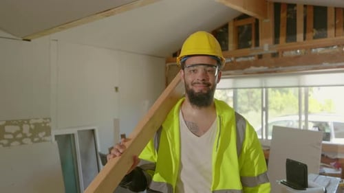 Construction Worker Carrying Lumber Inside Renovated House