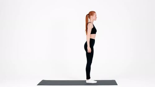 Mujer joven hace ejercicio con yoga y pilates sobre una colchoneta en un luminoso entorno de estudio
