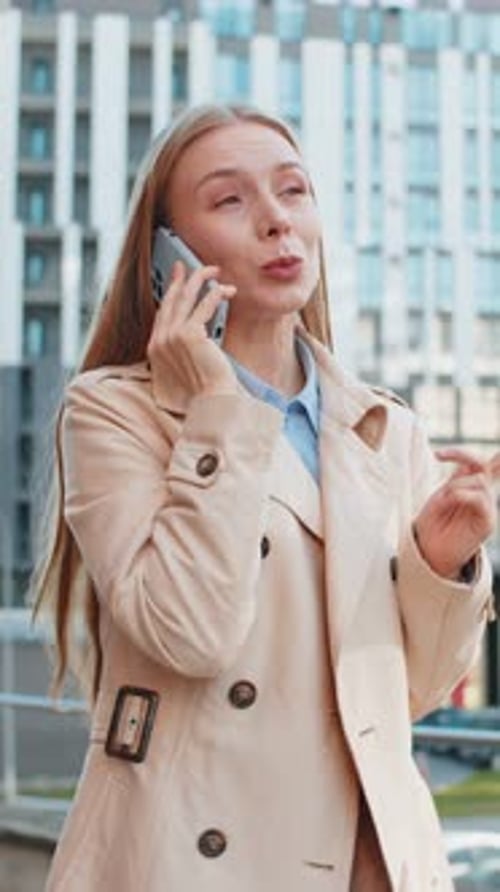 Mature Caucasian Businesswoman Having Remote Conversation on Smartphone on Downtown City Street
