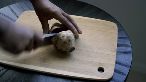 Cutting a purple Japanese potato in half Making a shitake mushroom and purple potato breakfast dish