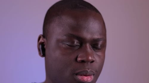 Man putting in wireless earbuds close up