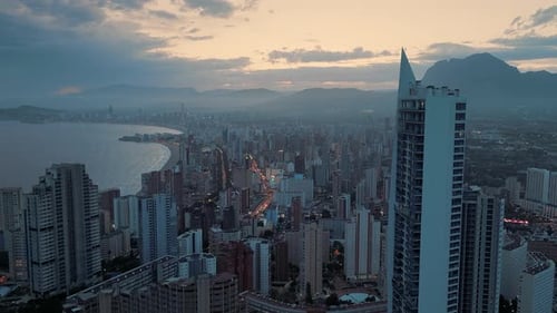 Modern seafront city in the evening when the sun is setting on a cloudy day.