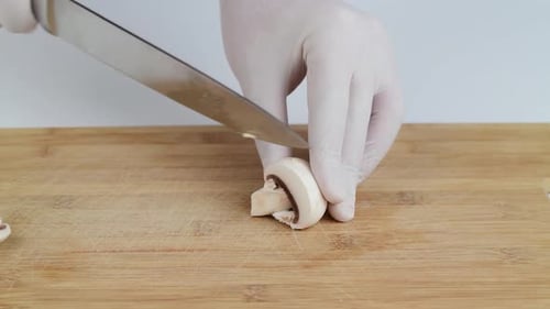 Mushroom Being Sliced on Wooden Cutting Board