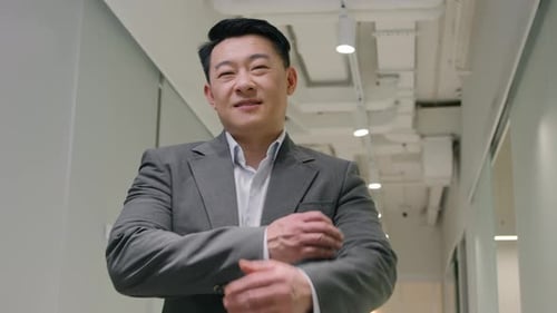 Smiling Businessman Standing Confidently in Office Hallway