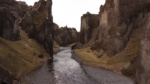 winding stream through towering cliffs of Fjaðrárgljúfur canyon Iceland