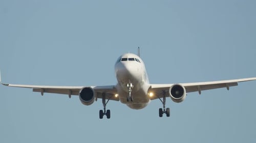 Approach of passenger airplane landing on airport runway during daylight