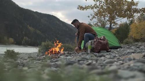 Hiker Tourist Traveler Man with Backpack Mountain Camping Fire Firewood Camp Tent Traveling Hiking