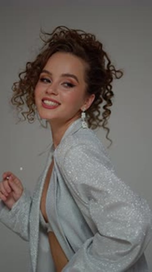 Smiling Woman Posing in Silver Jacket in Studio