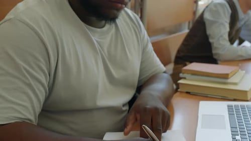 Jeune étudiant noir prenant des notes