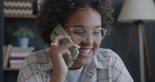 Woman Talking on Phone While Using Laptop