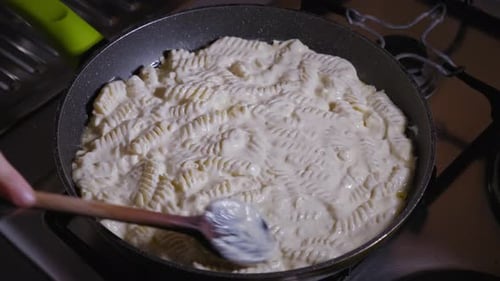 Pasta and Creamy Sauce Cooking in Pan