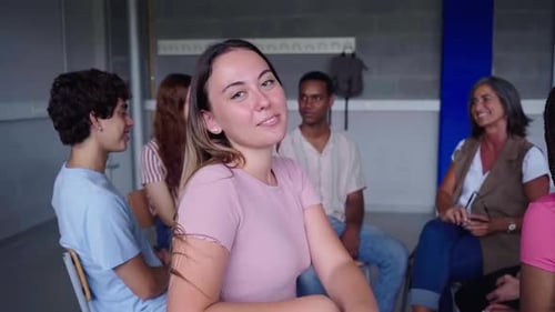 Portrait of Female Student Sitting in Circle with Schoolmates at Class Looking at Camera Smiling