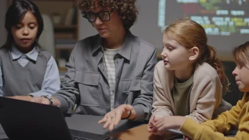 Trois enfants issus de différentes ethnies discutent avec un enseignant