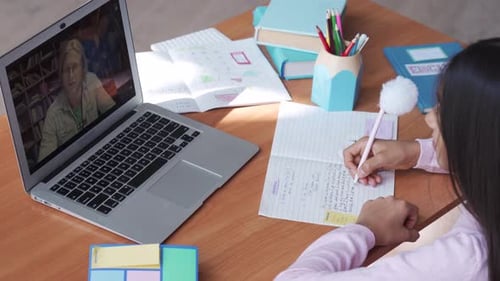 Child having online class with teacher on laptop