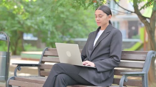 Woman Working On Laptop Outdoors in Park